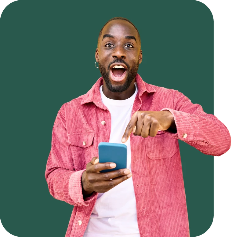 Excited man in a pink shirt pointing at his phone